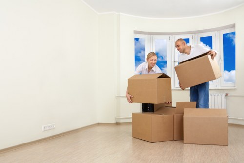 Movers carrying household items through a flat in West Hampstead